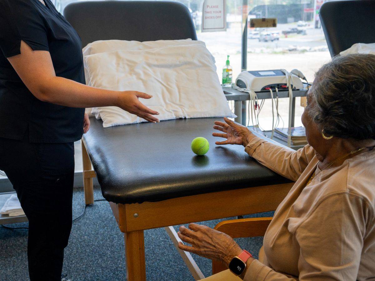 Senior patient practicing hand-eye coordination with a tennis ball