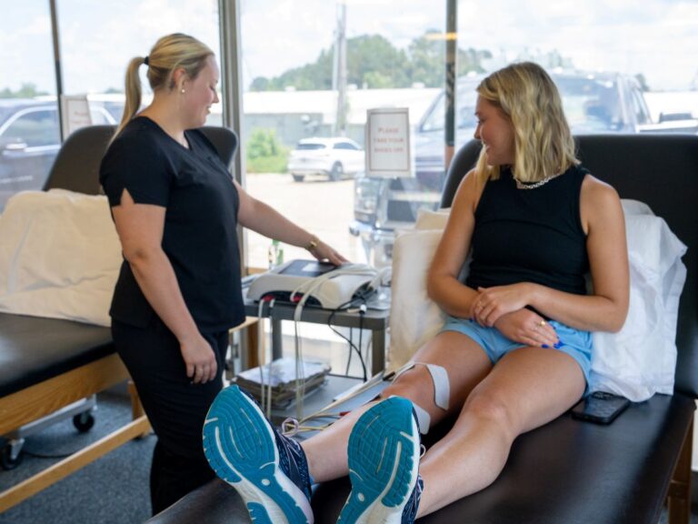 Therapist and young adult preparing for electrotherapy session