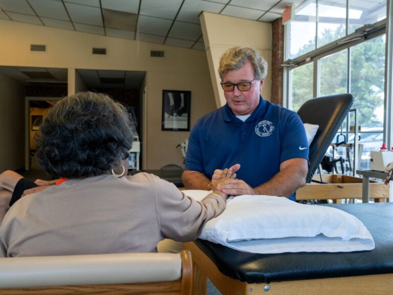 Therapist holding a patient's hand for manual therapy treatment