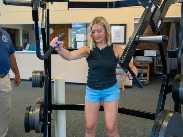 Therapist coaching patient on proper equipment use during therapy