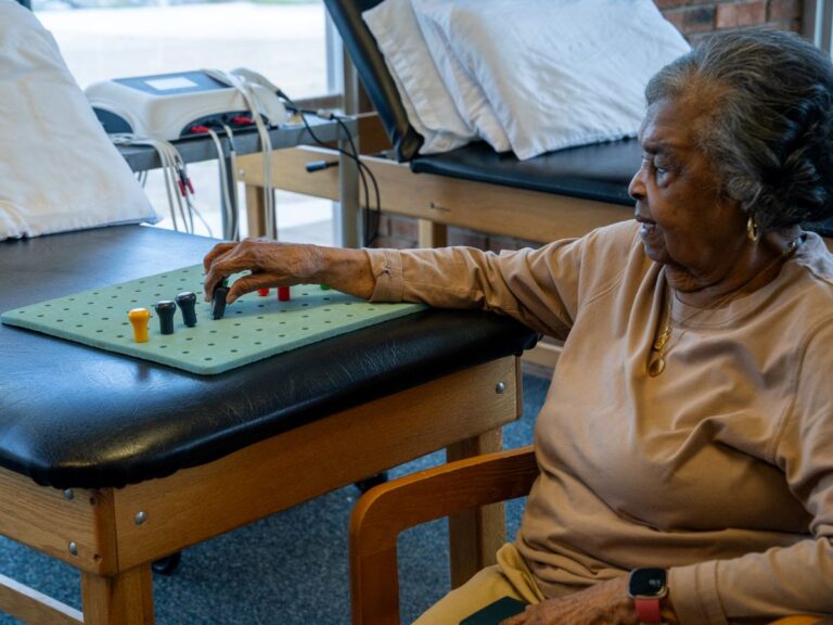 Senior woman working on a pegboard for hand therapy